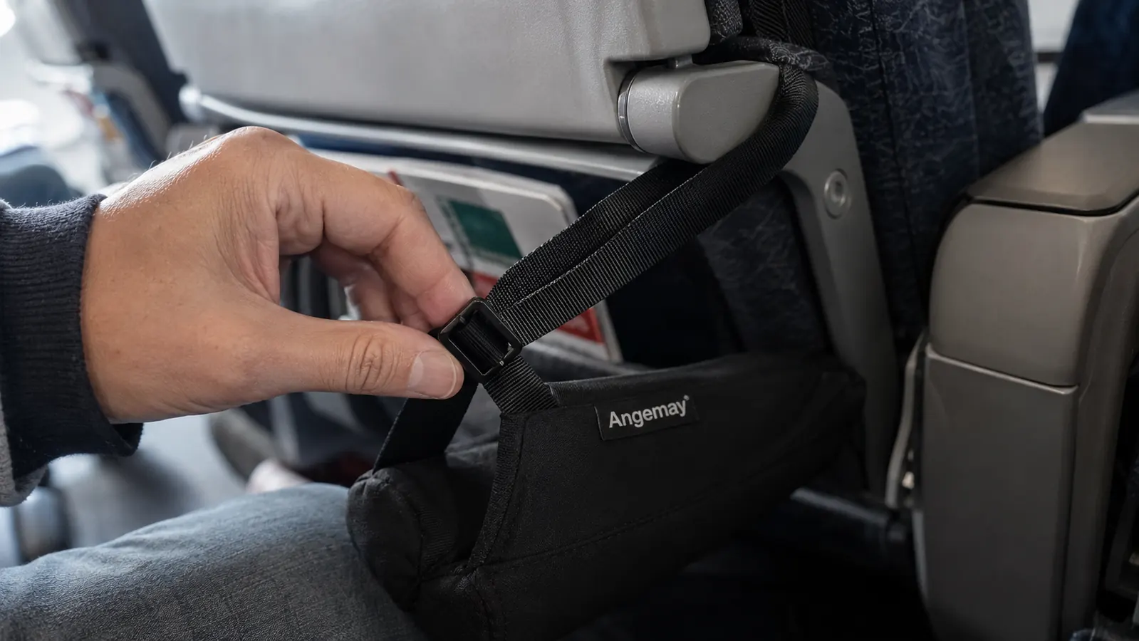 Close-up of a hand re-tightening a loosened footrest strap buckle mid-flight