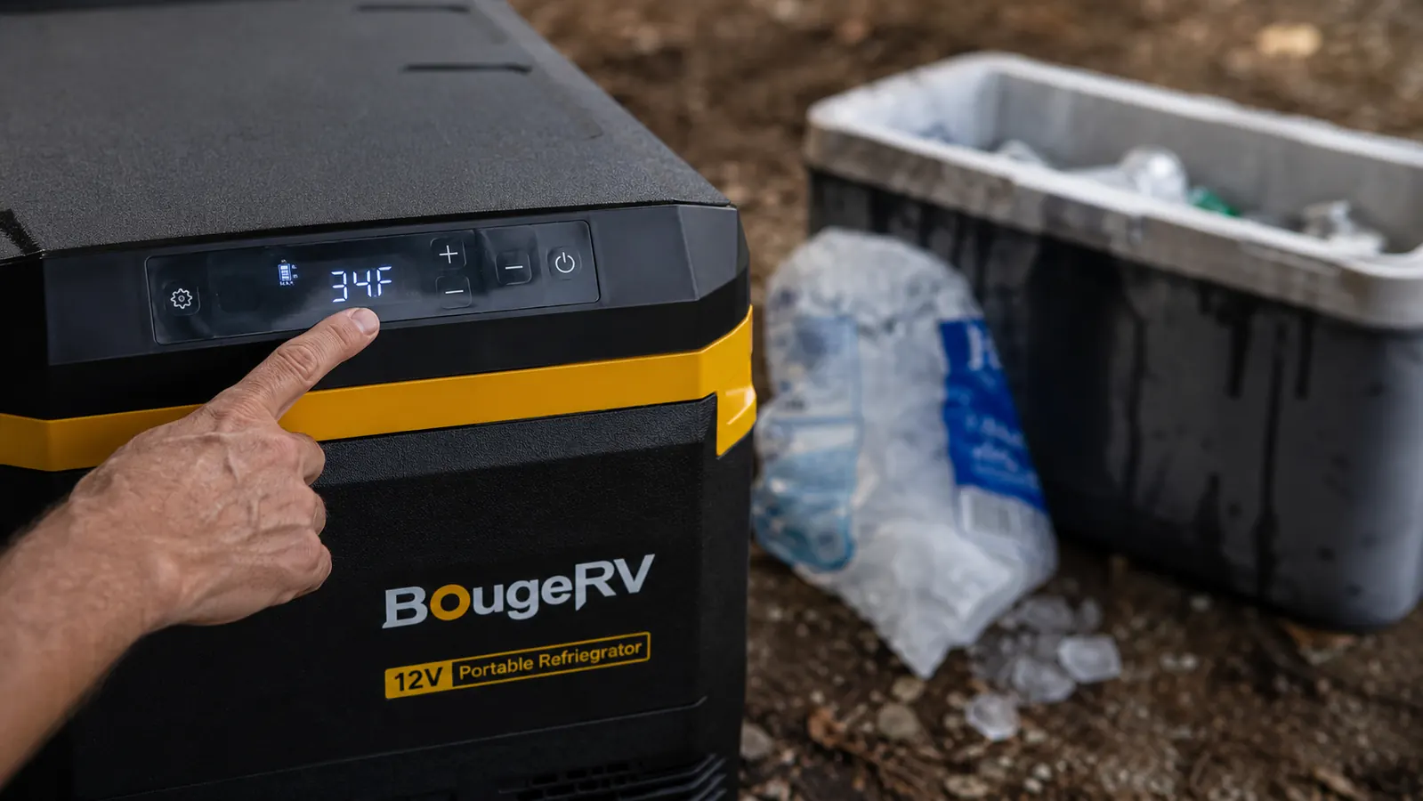 Close-up of the BougeRV fridge's digital temperature display reading 34 degrees Fahrenheit next to a bag of melting ice from a traditional cooler