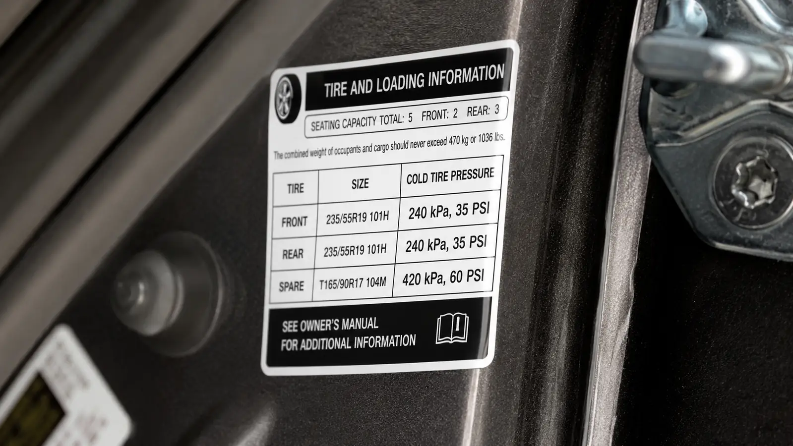 Close-up of a driver's side door jamb sticker listing the recommended tire pressure specification